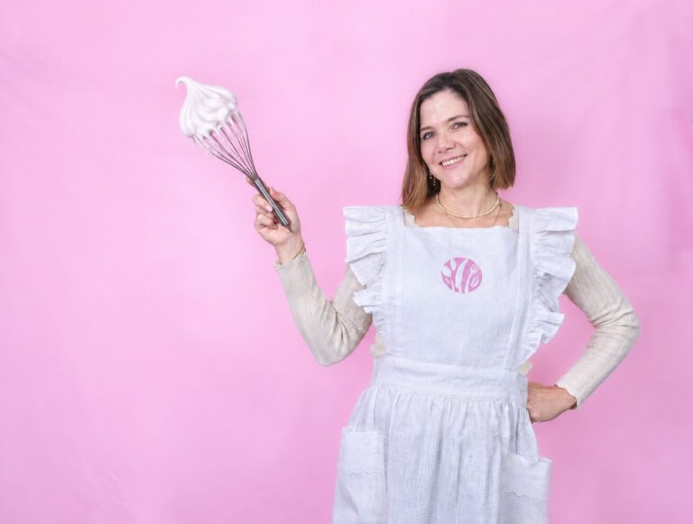 Claudia enseñando a hacer merengue con un batidor lleno de merengue montado