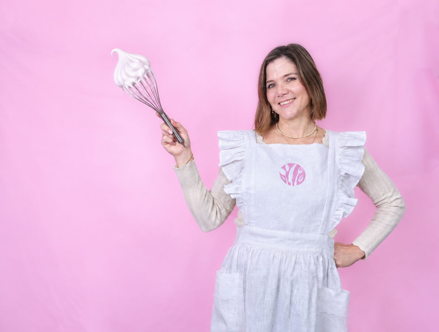 Claudia enseñando a hacer merengue con un batidor lleno de merengue montado